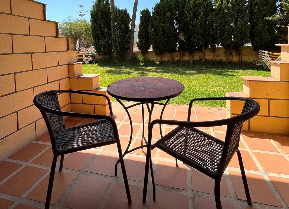 dos sillas y una mesa en un patio de ladrillos