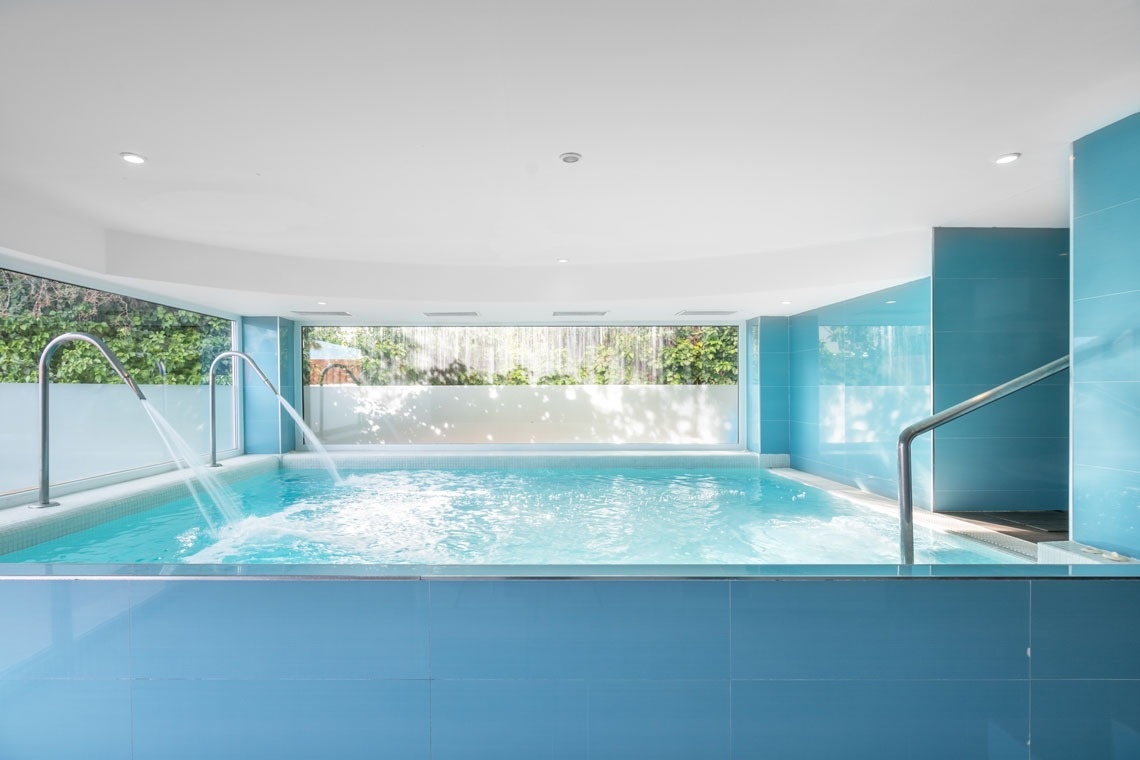 una piscina azul y blanca con escaleras que conducen a ella