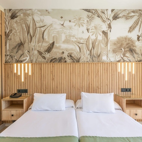 a hotel room with two beds and a mural on the wall