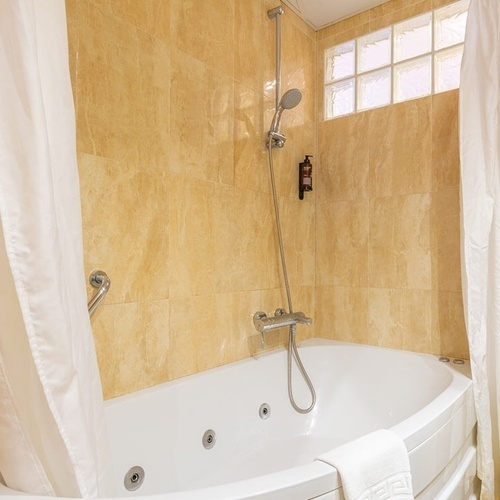 un baño con una bañera y una cortina de ducha
