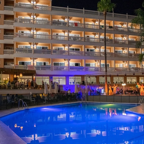 la piscina está iluminada con luces azules en la noche