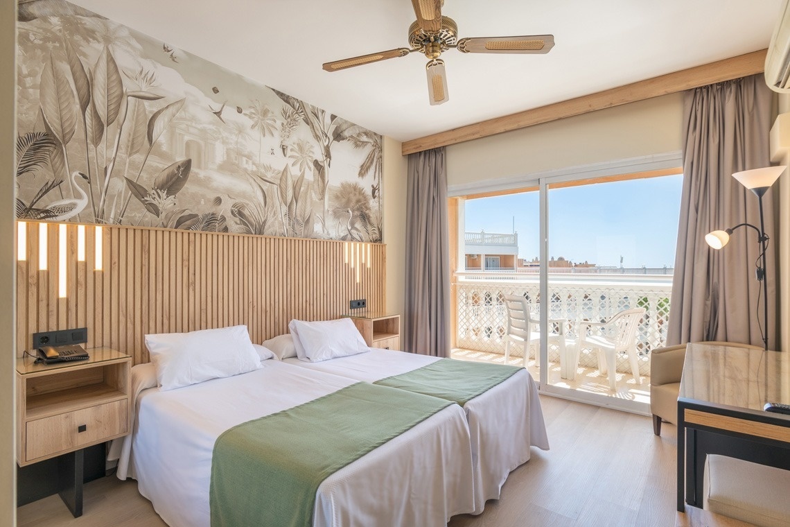 a hotel room with two beds and a ceiling fan