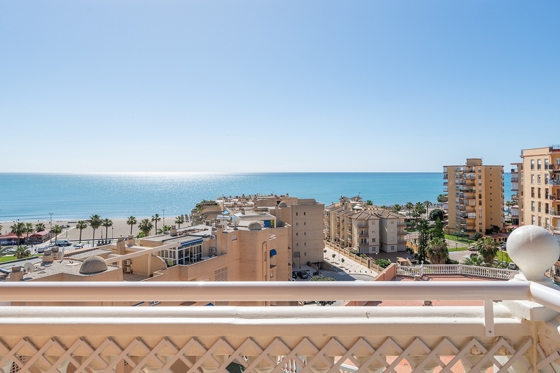 a balcony with a view of the ocean and buildings