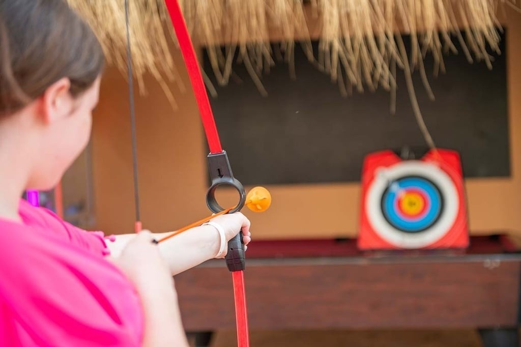 Enfant participant à une activité de tir à l'arc ludique à l'hôtel.