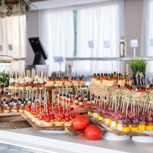 a buffet table with a variety of food on skewers