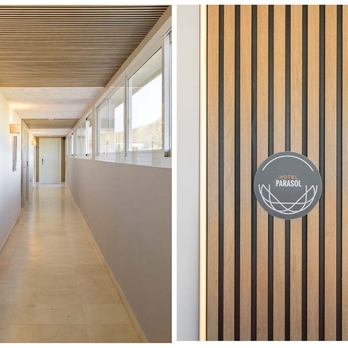 La imagen muestra un pasillo de hotel moderno con techo de listones de madera y ventanas laterales, junto a un detalle del letrero redondo del 