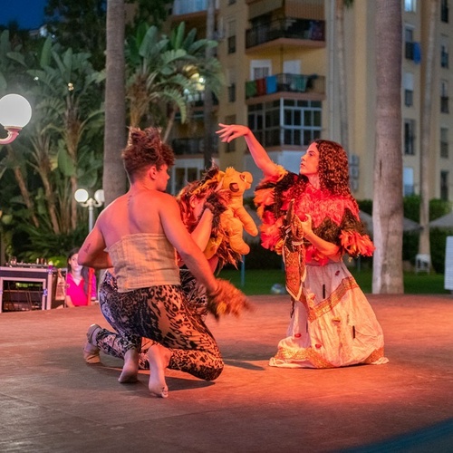 un hombre y una mujer están actuando en un escenario por la noche