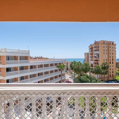 a balcony with a view of a hotel and the ocean