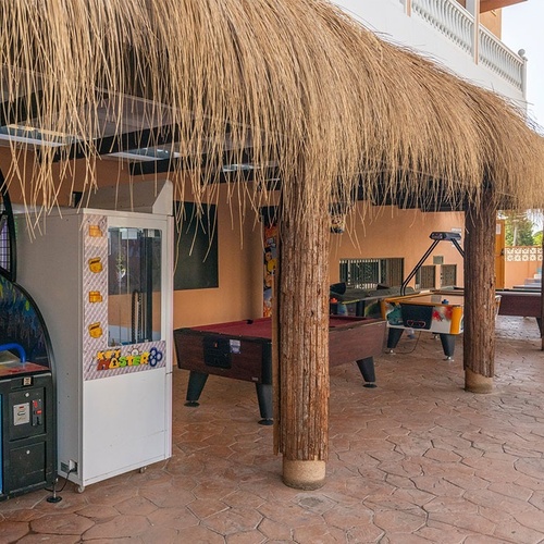 a machine that says ' basketball ' on it sits under a thatched roof