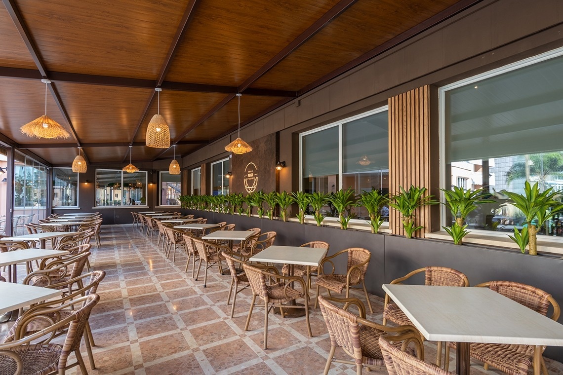 una larga fila de mesas y sillas en un restaurante