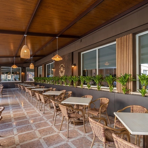 a restaurant with wicker chairs and white tables