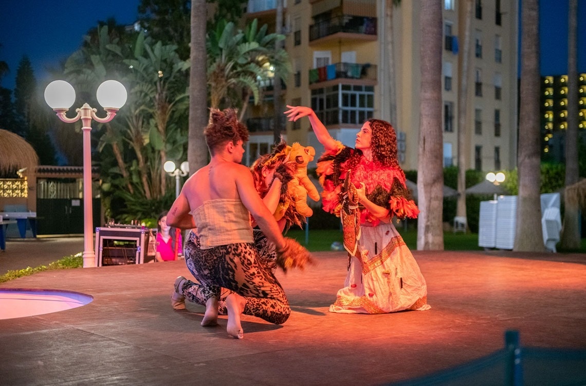 a man and a woman are performing on a stage at night