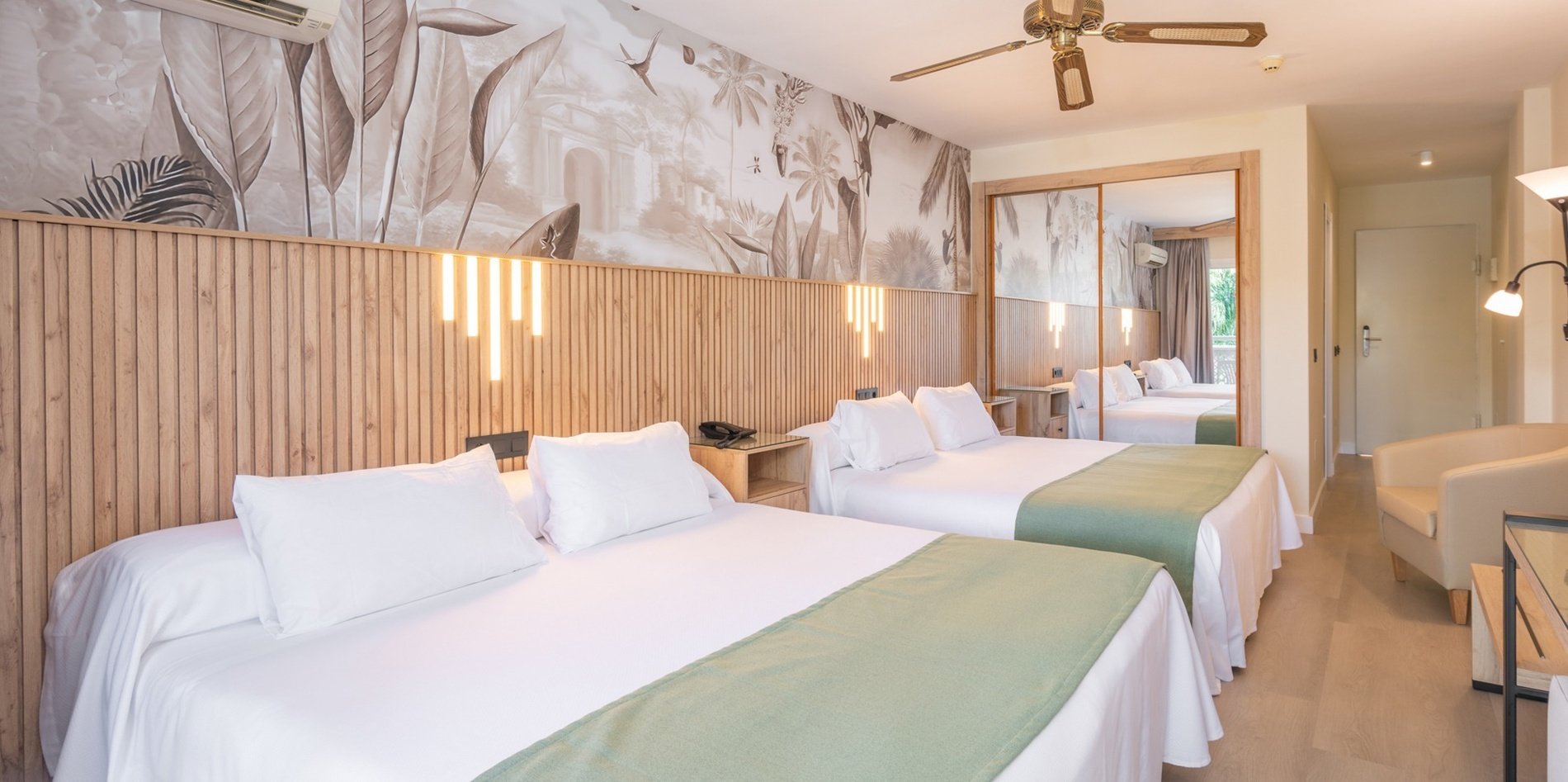 una habitación de hotel con dos camas y un ventilador de techo