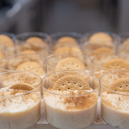 un montón de vasos llenos de comida con galletas encima