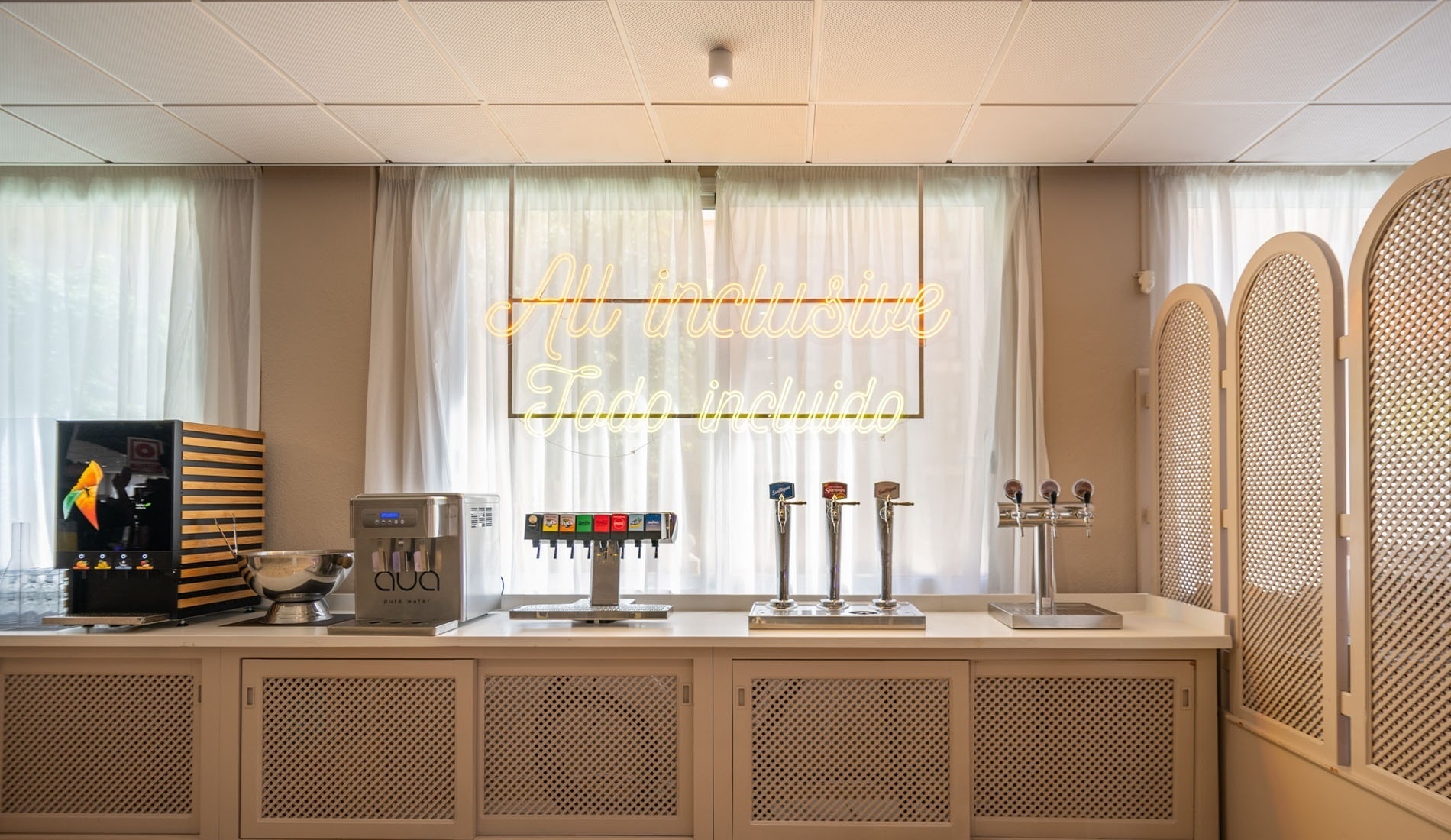 a large room with tables and chairs and a neon sign that says cocktails