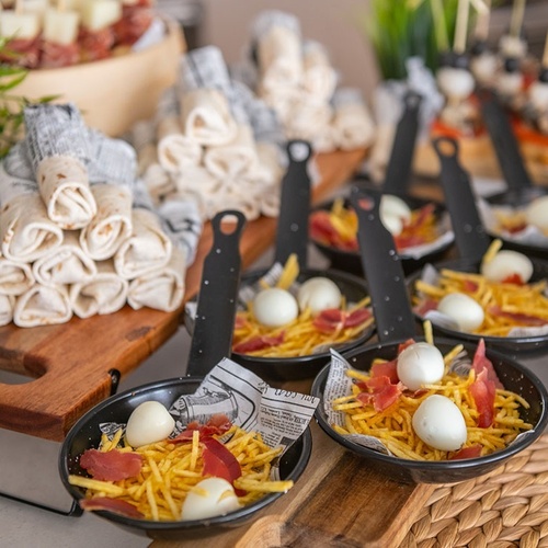 a bowl of food with eggs and french fries on a table