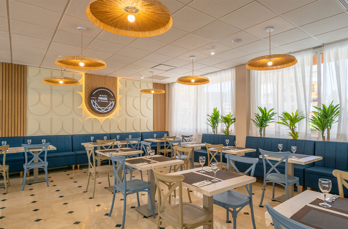 Elegant hotel dining room with Dorobe: Parasol by Parasol, featuring blue booths, light wood tables, and woven light fixtures.