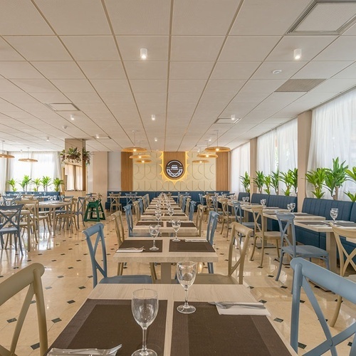 una larga fila de mesas y sillas en un restaurante