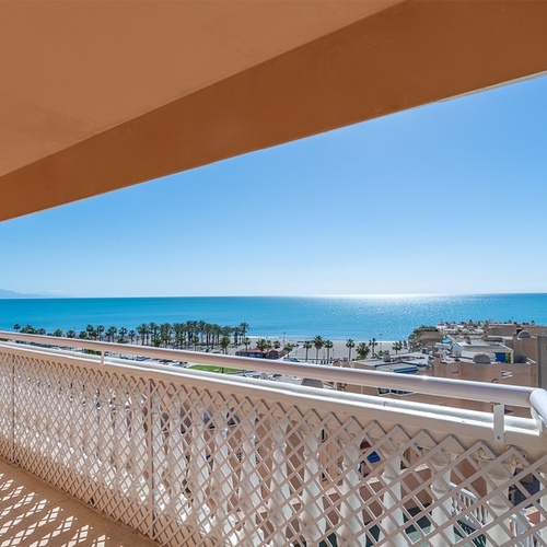 a balcony overlooking the ocean with a white railing