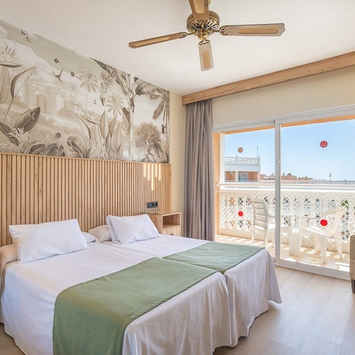 a hotel room with two beds and a ceiling fan