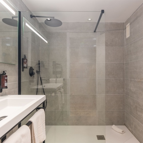 un baño con un lavabo y una ducha de vidrio