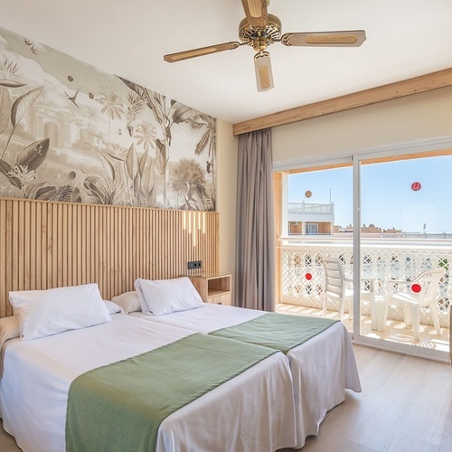 una habitación de hotel con dos camas y un ventilador de techo