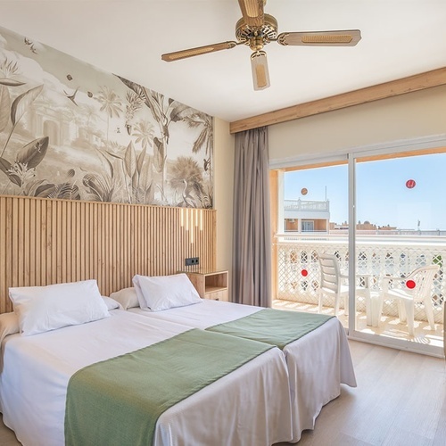 a hotel room with two beds and a ceiling fan