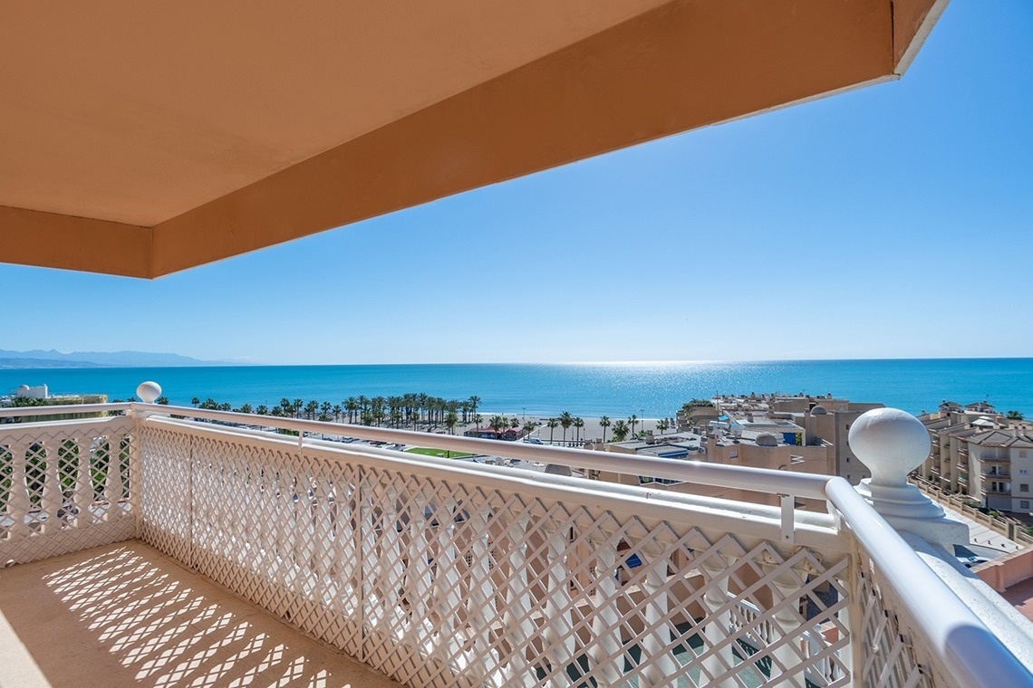 a balcony overlooking the ocean with a white railing