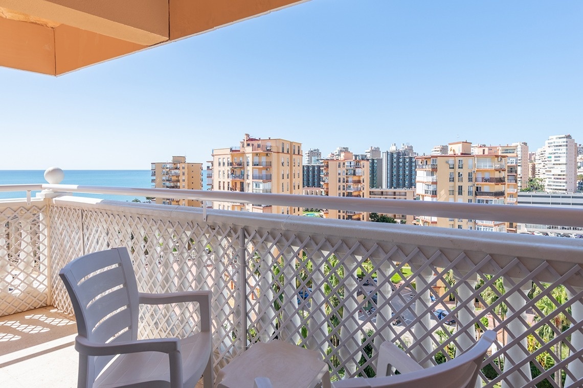 a balcony with a view of the ocean and buildings
