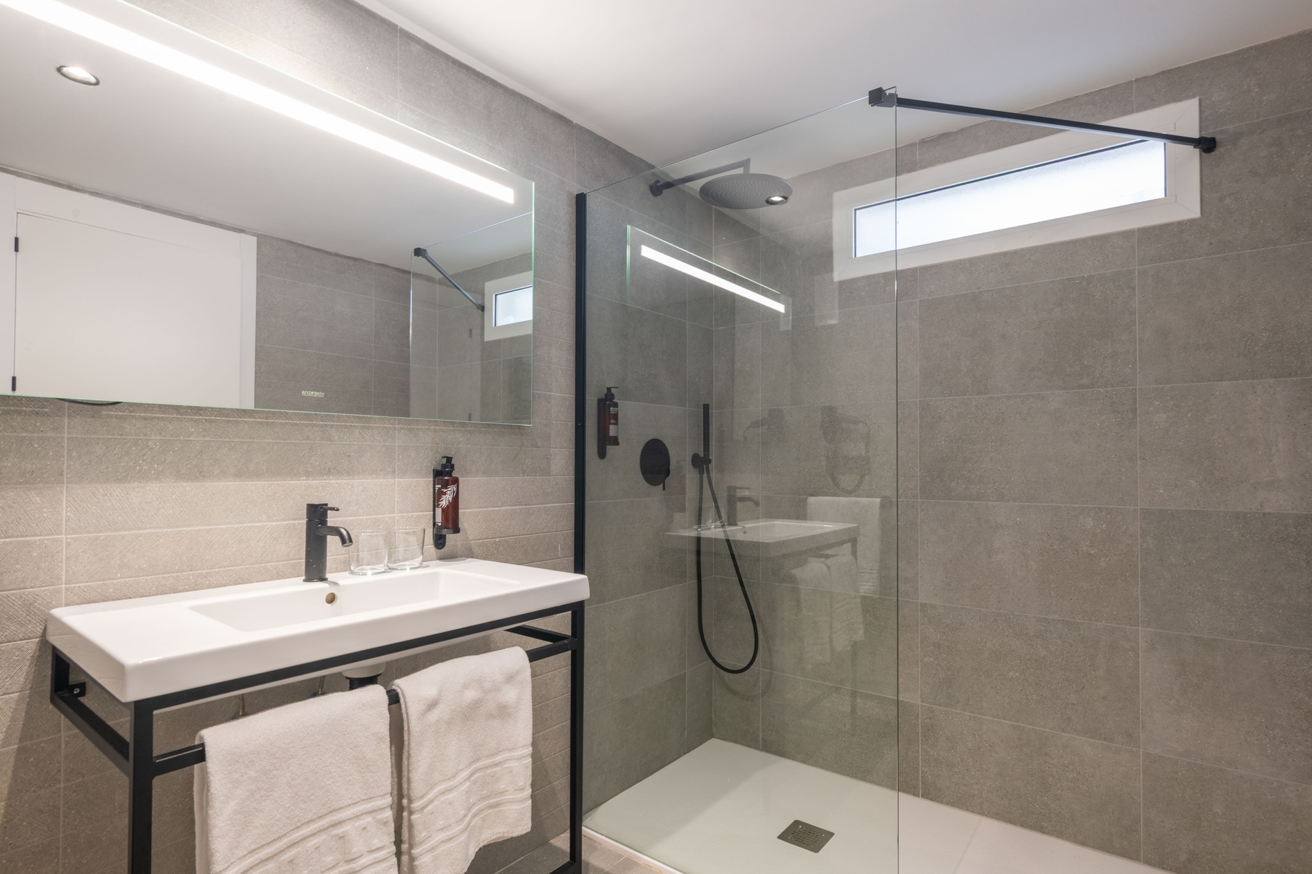 un baño con un lavabo y una ducha de vidrio