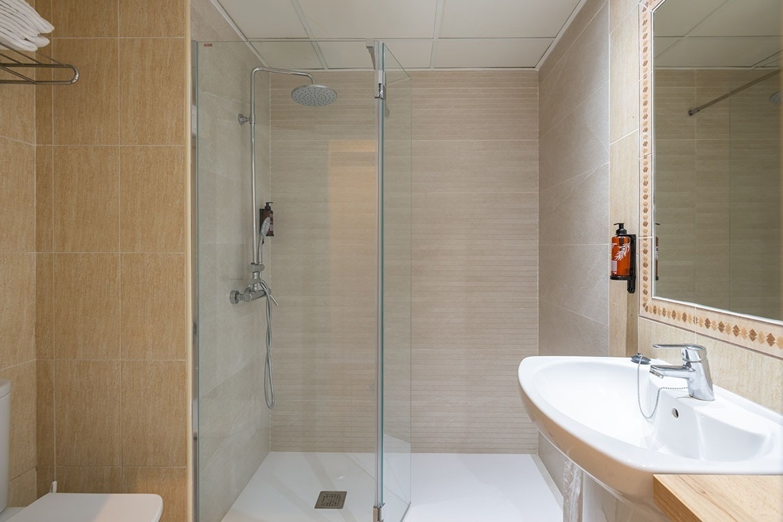 a bathroom with a walk in shower and a sink