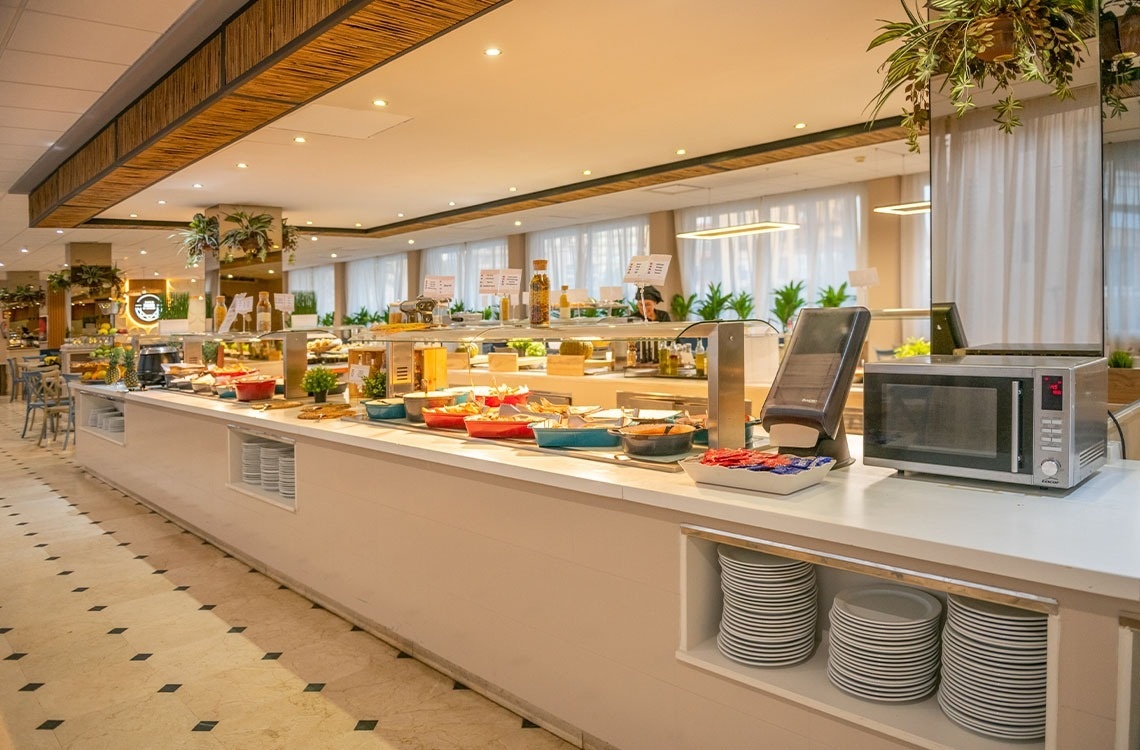 a buffet line in a restaurant with plates and a microwave