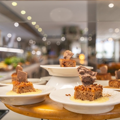 a display of desserts with a plant in the background