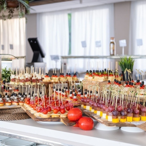 a buffet table with a variety of food on skewers