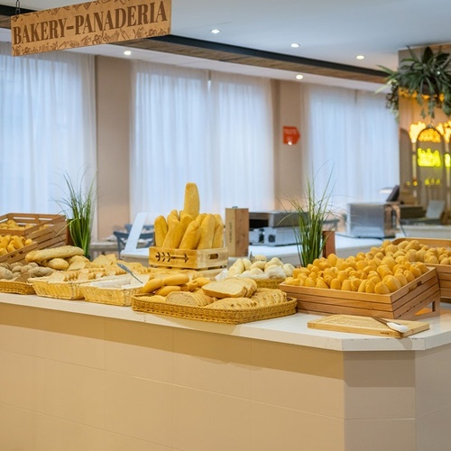 a bakery-panadera sign hangs above a counter full of bread