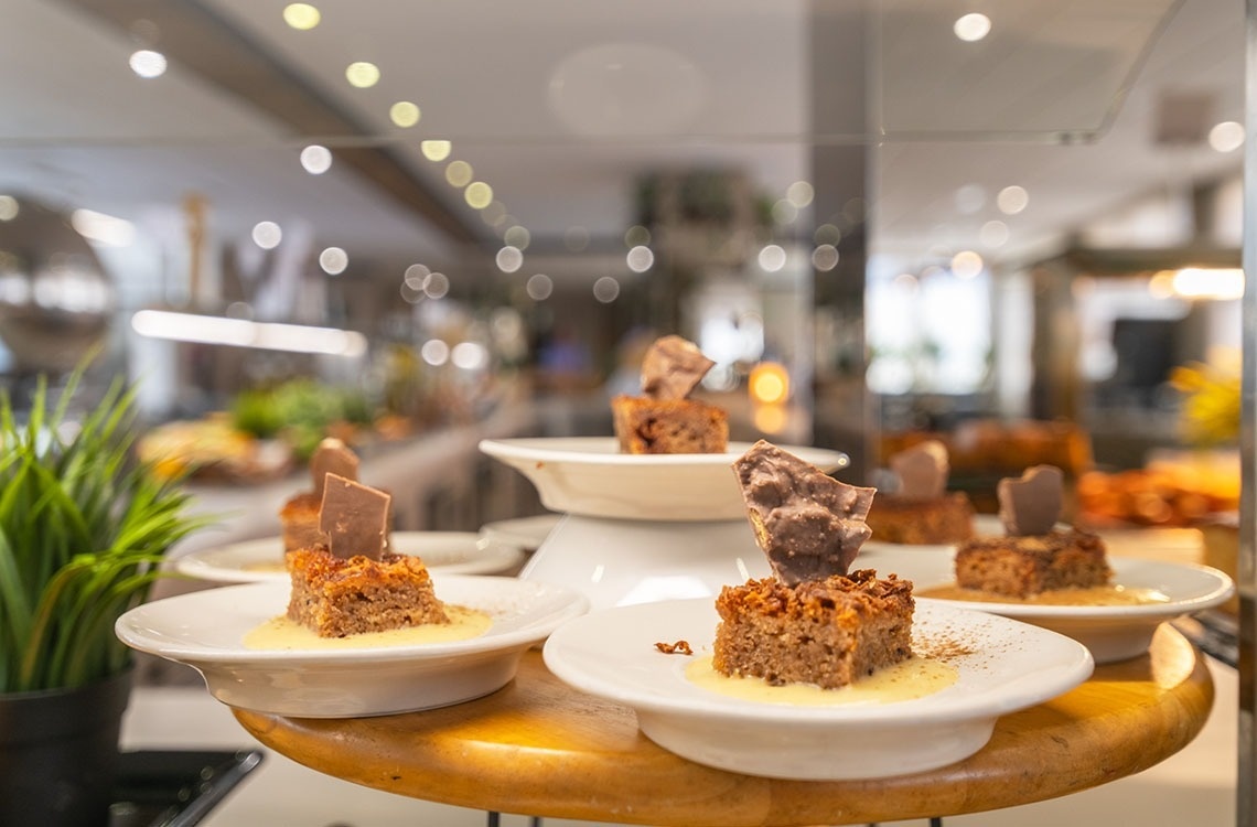 a display of desserts on a table with a plant in the background