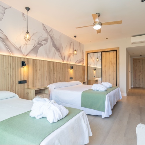 una habitación de hotel con dos camas y un ventilador de techo