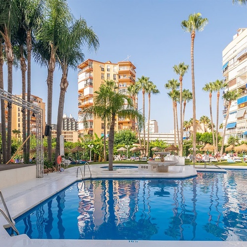 una gran piscina rodeada de palmeras y edificios