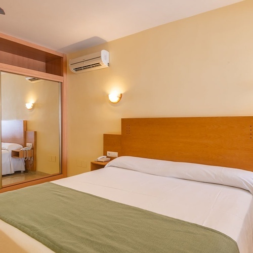 a hotel room with a bed and a ceiling fan