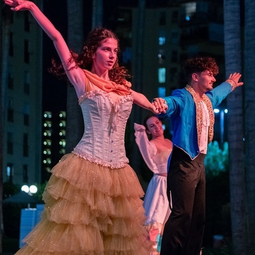 un hombre y una mujer bailan juntos en un bosque por la noche