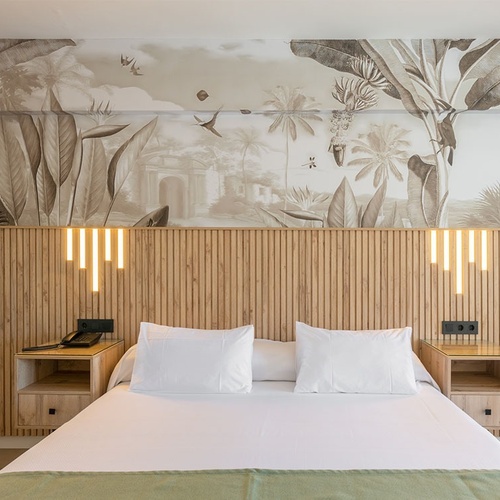 a bedroom with a large mural on the wall above the bed