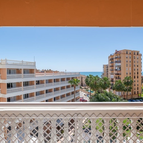 a balcony with a view of a hotel and the ocean