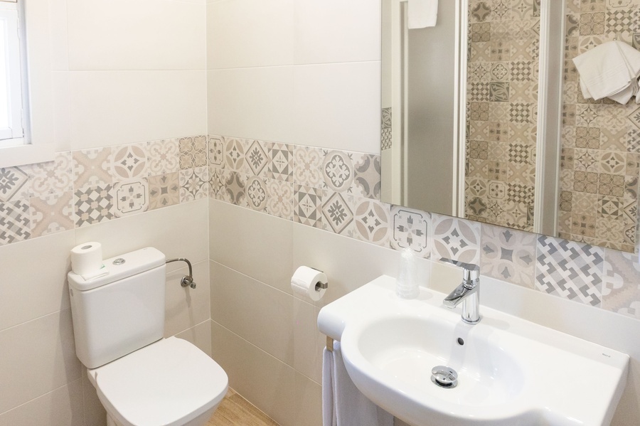 a bathroom with a toilet a sink and a mirror