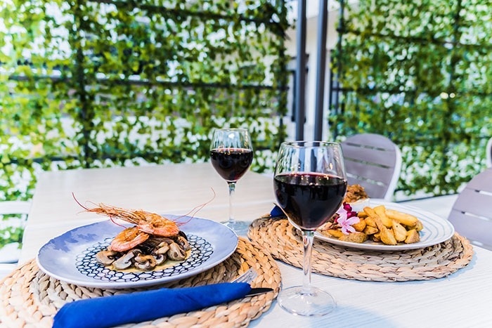 una mesa con platos de comida y copas de vino