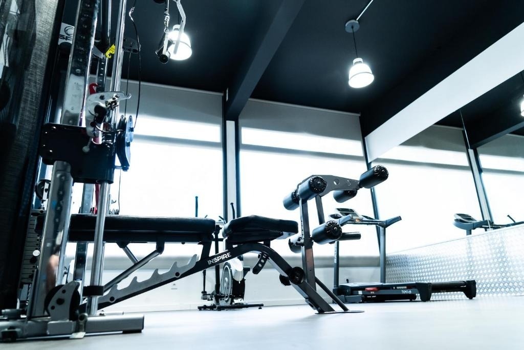 un gimnasio con un banco y una cinta de correr