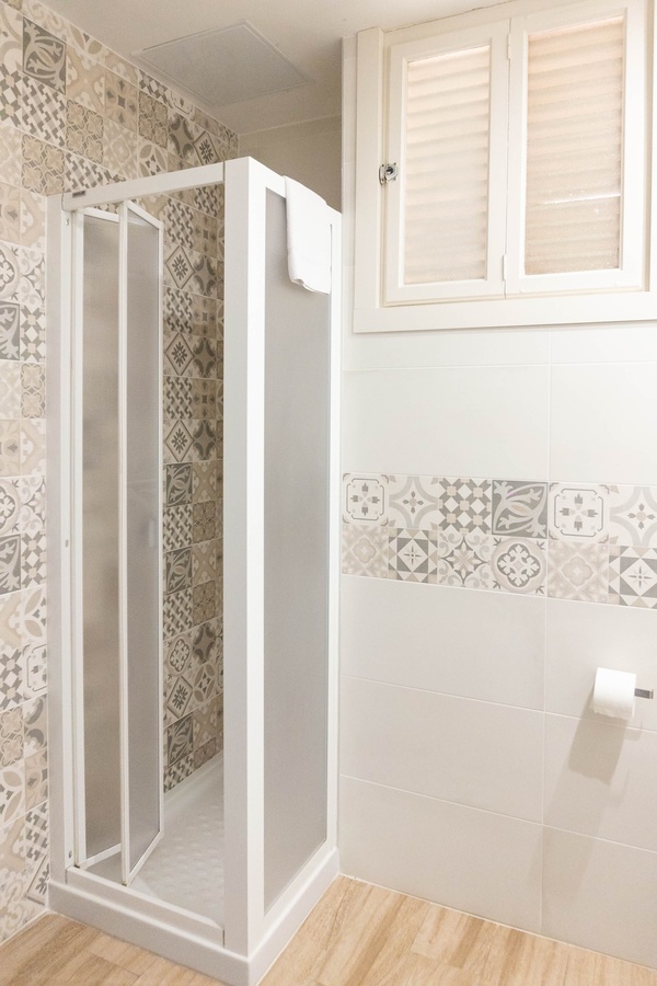 a bathroom with a shower stall and a window