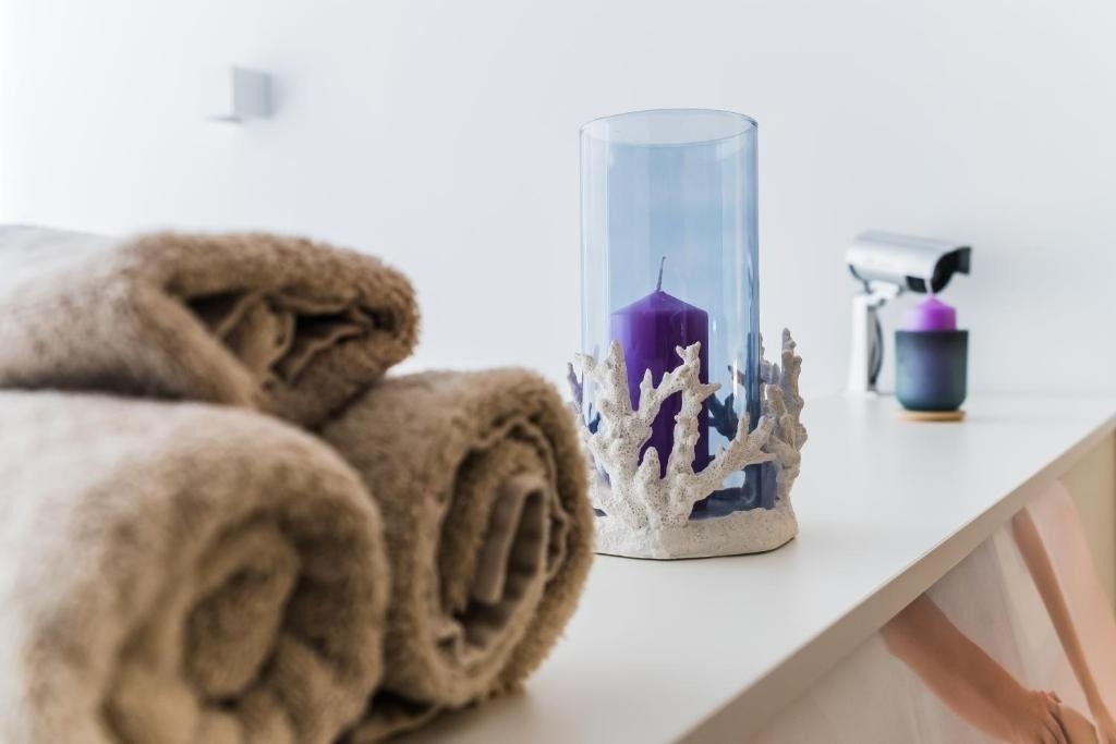 una vela morada está en un jarrón de coral