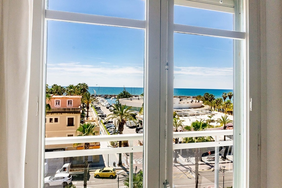 a window with a view of a city and the ocean