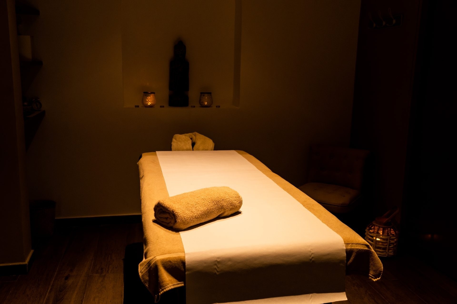 una mesa de masaje con toallas y velas en una habitación oscura