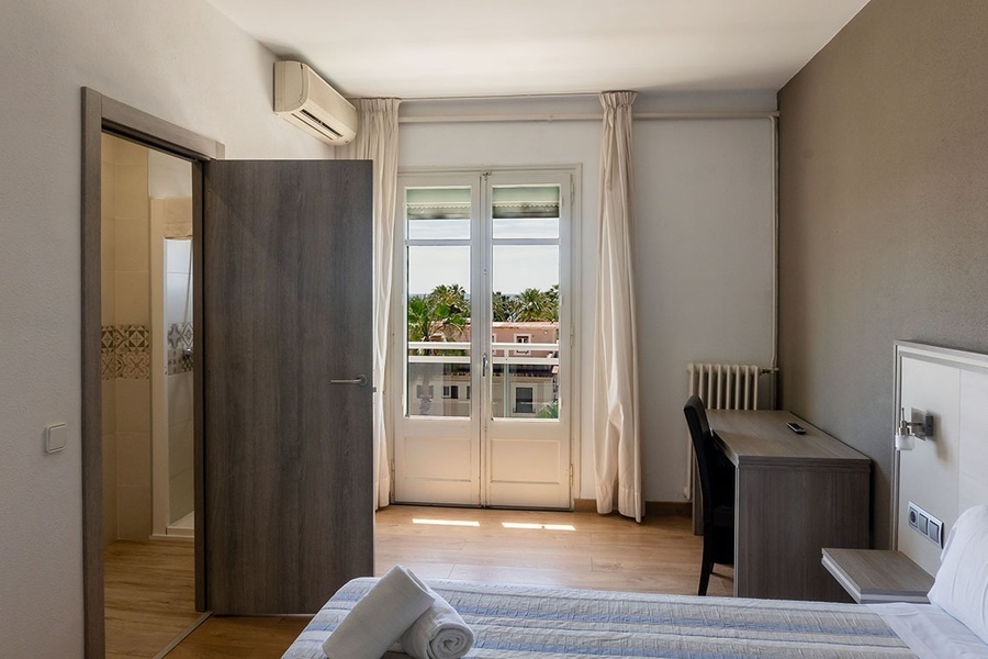 a hotel room with a bed and a desk
